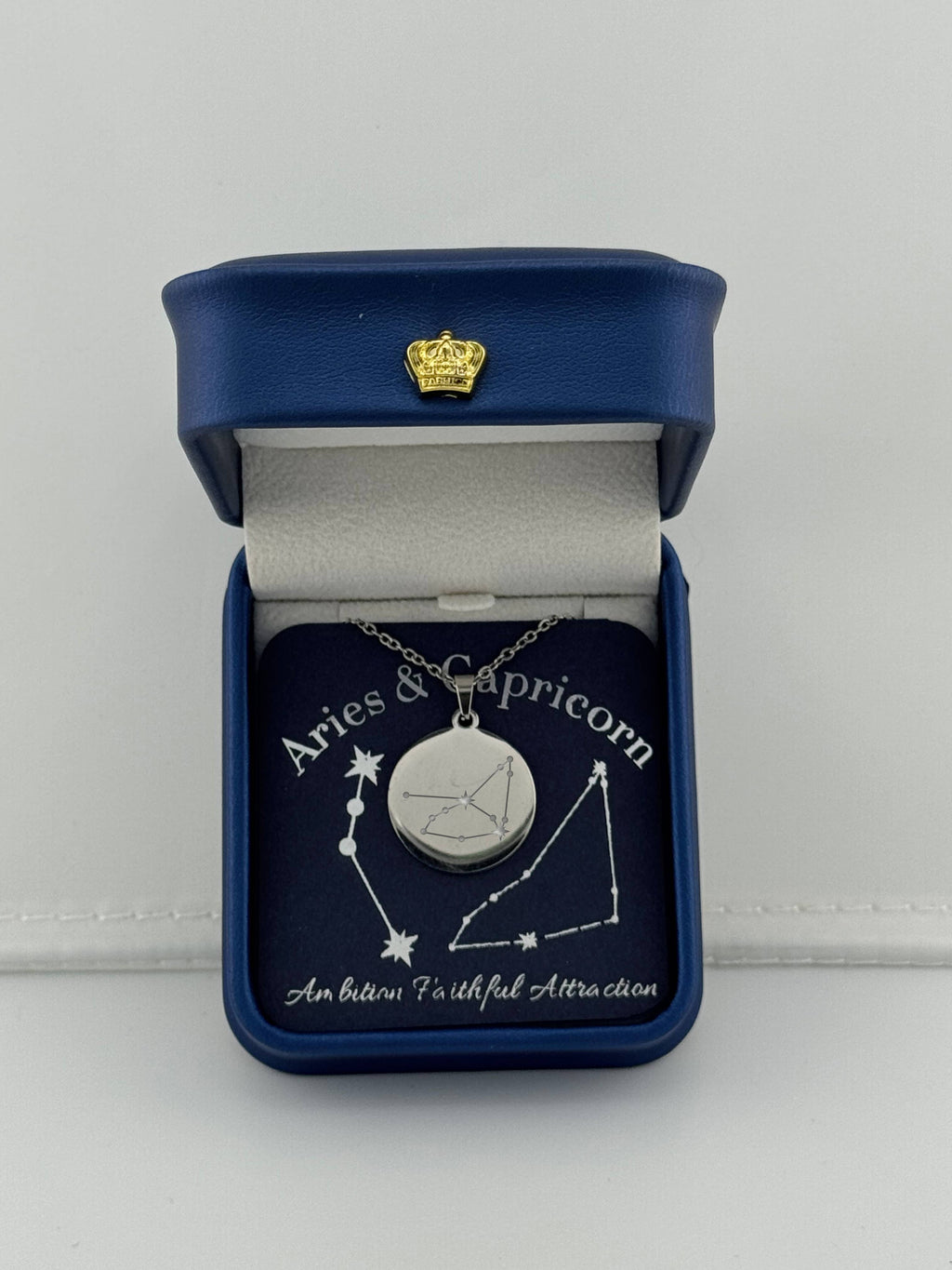 Silver Aries + Capricorn constellation medallion necklace in gift box with silver foil zodiac card

