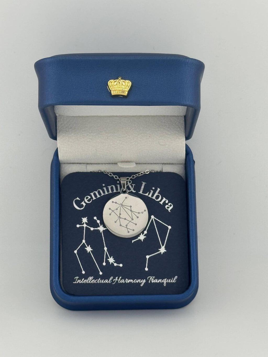 Silver Gemini + Libra constellation medallion necklace in gift box with silver foil zodiac card
