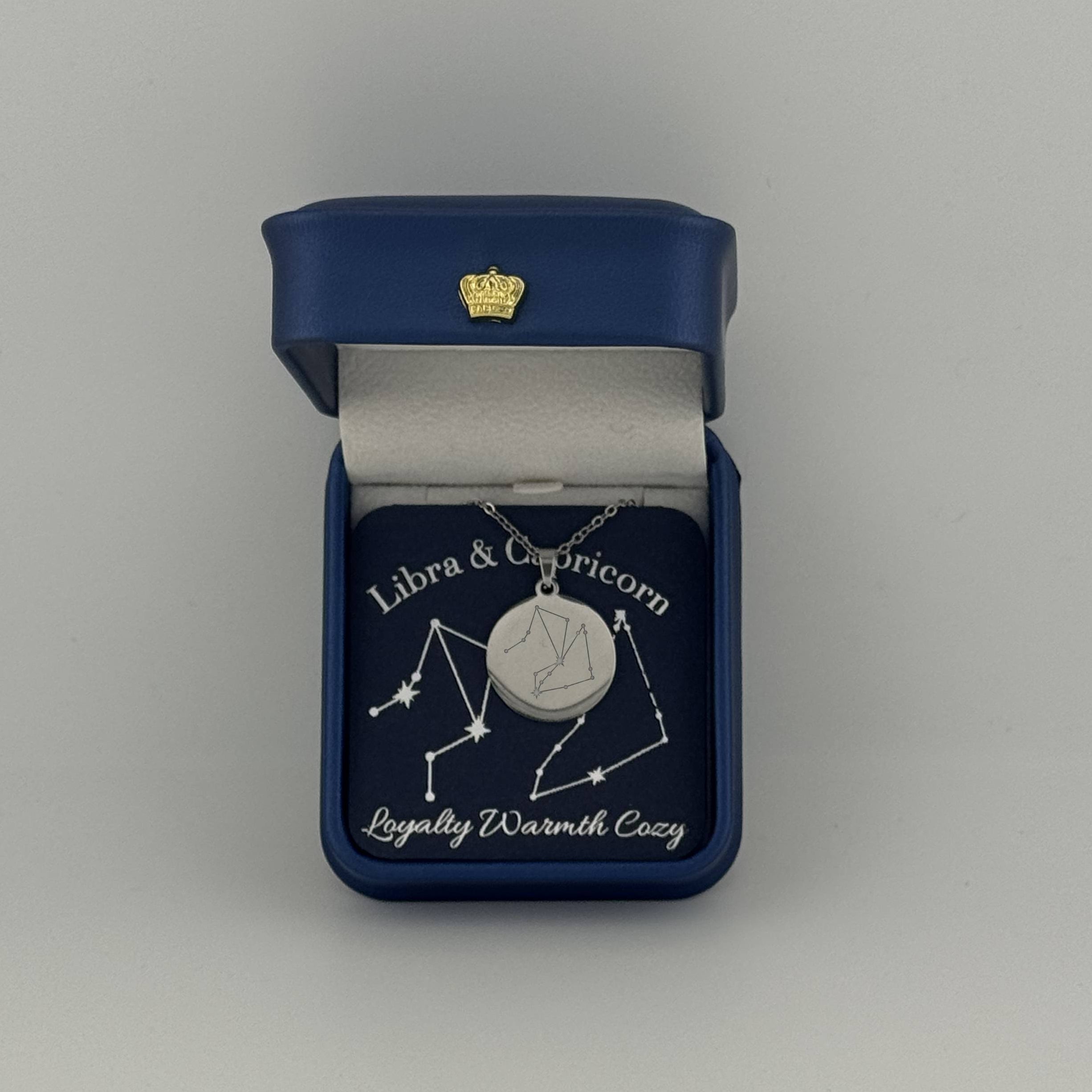 Silver Libra and Capricorn constellation medallion necklace in gift box with silver foil zodiac card
